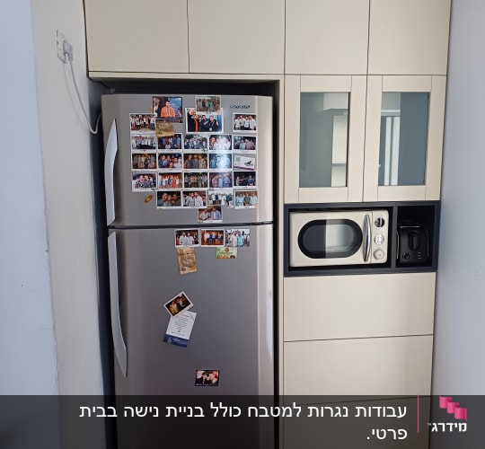 מטבח עם מקרר ותמונות על הדלת